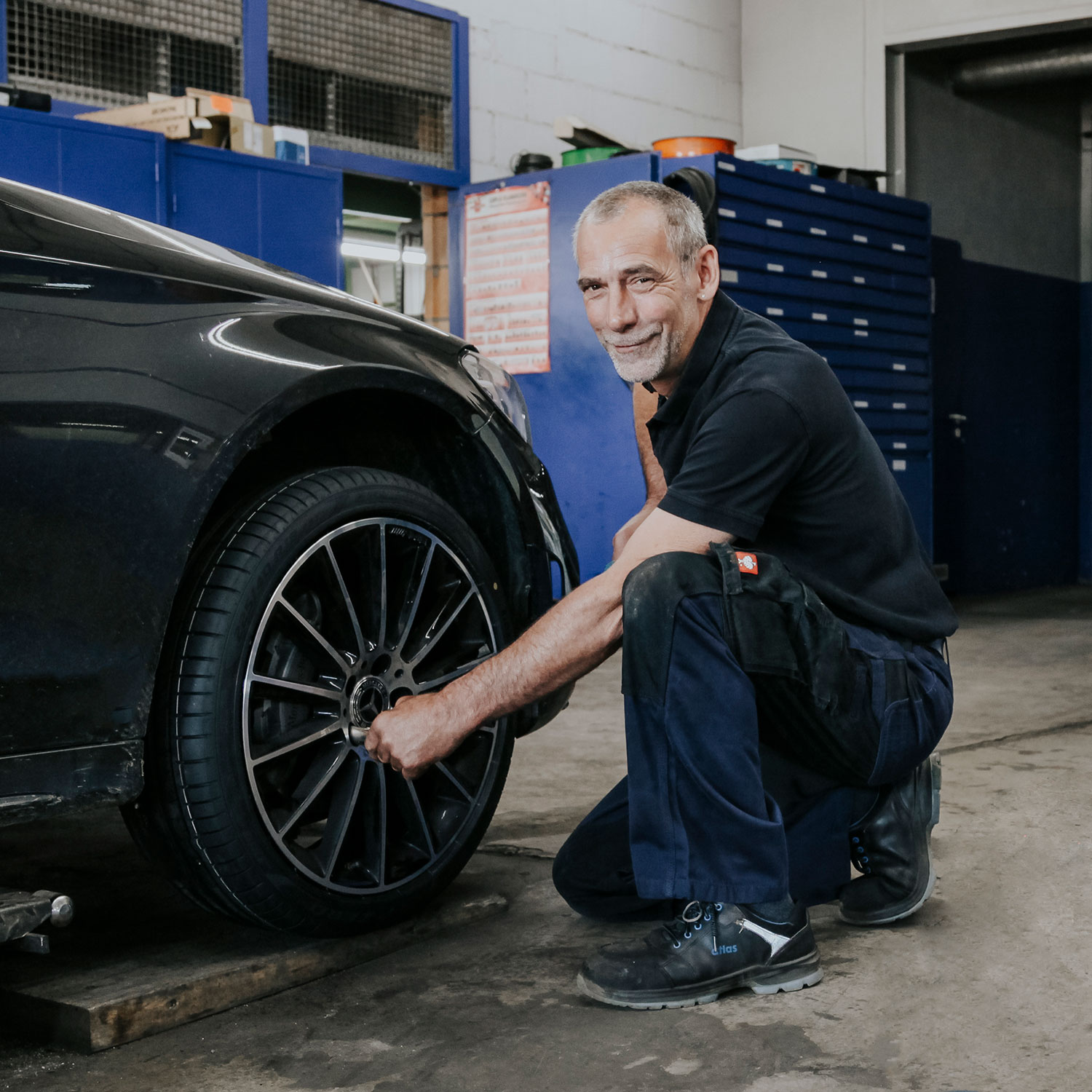 Employé d’un grossiste en pneus avec une tablette dans un atelier automobile